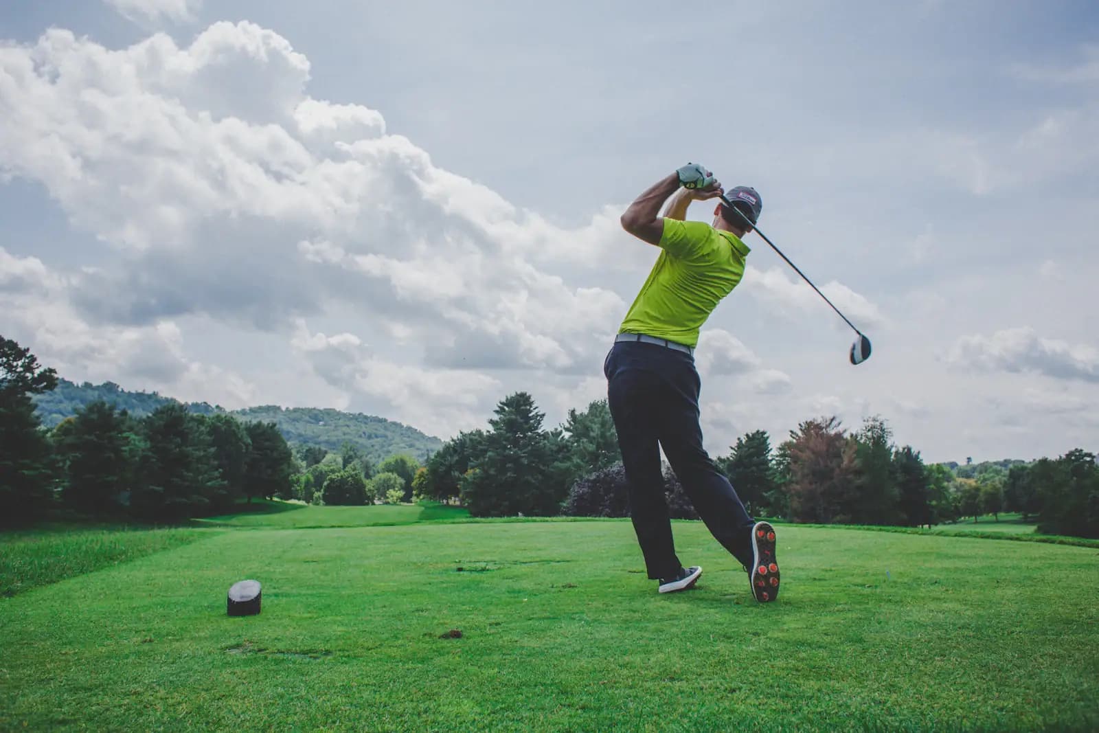 Golfista en pleno swing sobre el fairway del Ruitoque Golf Country Club, con las montañas al fondo